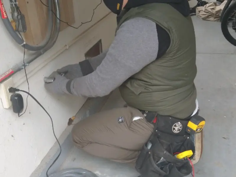 Electrician performing outlet wiring in a Berne garage
